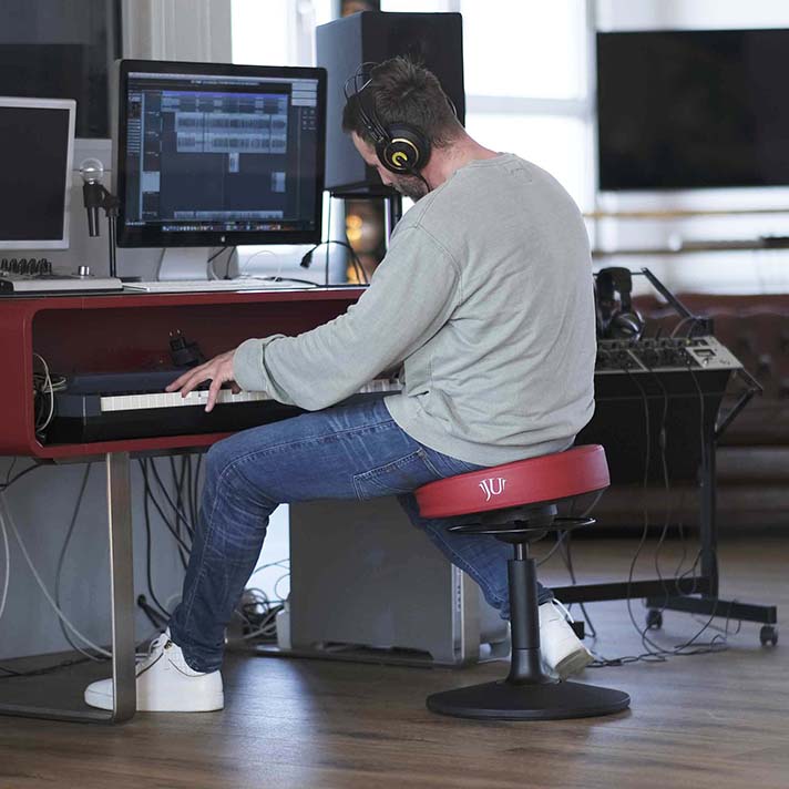 Bürohocker ergonomisch mit mann der Musik macht